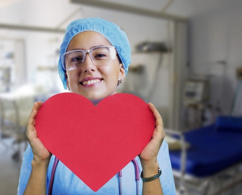 Jeune femme souriante tenant un coeur en papier