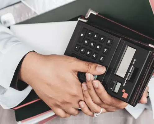 personne tenant des documents et une calculatrice
