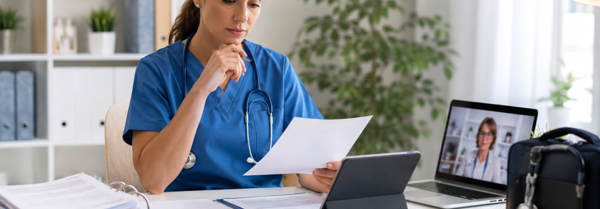 Infirmière libérale comparant sa facturation médicale sur ordinateur avec documents administratifs